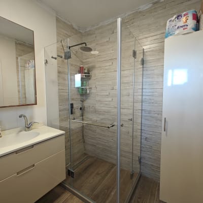 מקלחון זכוכית עם ראש מקלחת ומדף מוצרים