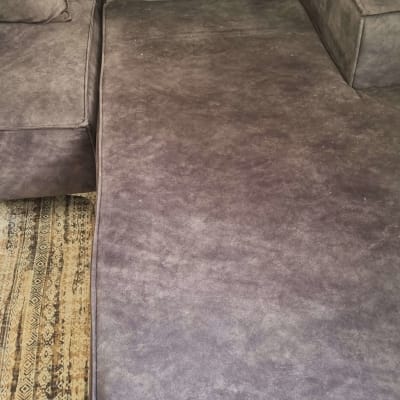 ספה אפורה עם ריפוד על שטיח דקורטיבי