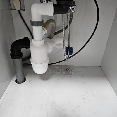 צנרת פלסטיק מתחת לכיור עם מחברים וברזים