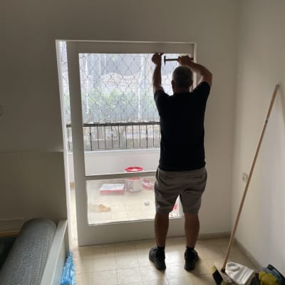 אדם מודד חלון זכוכית עם מטר