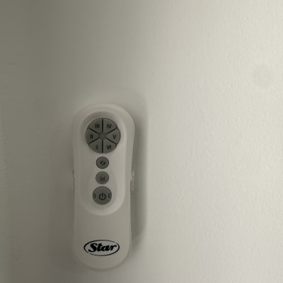 שלט רחוק עם כפתורים על קיר לבן