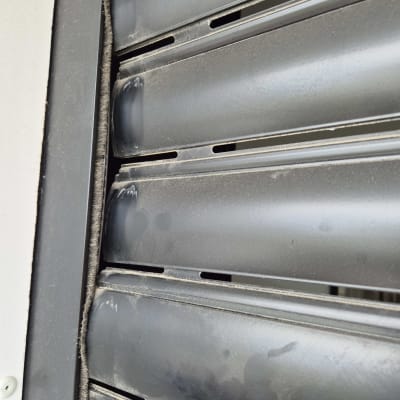 תריסים מתכתיים עם אבק ומסגרת כהה