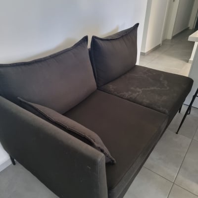 ספה דו מושבית כהה על רצפת אריחים אפורה