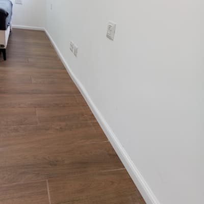 רצפת פרקט עץ חום ליד קיר לבן