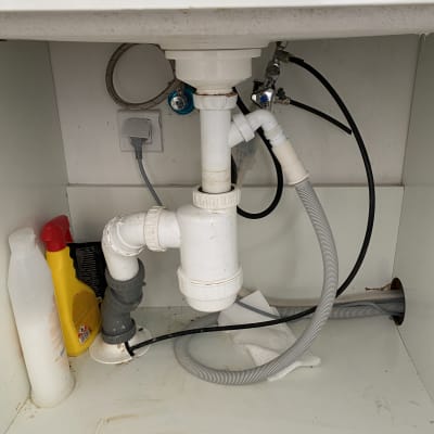 צנרת מתחת לכיור עם חיבורים וצינורות