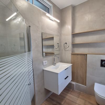 חדר אמבטיה עם כיור תלוי, מקלחון וזכוכית מחוספסת