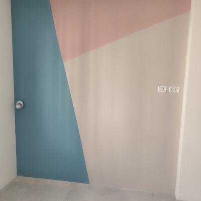 קיר צבוע בצבעים כחול וורוד עם עיצוב גיאומטרי