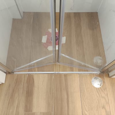 דלת זכוכית במקלחת עם רצפת עץ