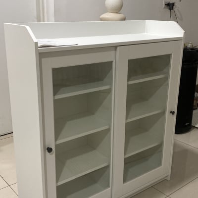 ארון לבן עם דלתות זכוכית ומדפים פנימיים