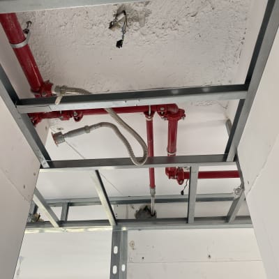 צינורות כיבוי אש אדומים בתקרה עם חיבורים