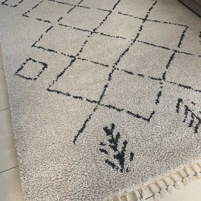 שטיח בהיר עם דוגמת ריבועים שחורים על רצפה