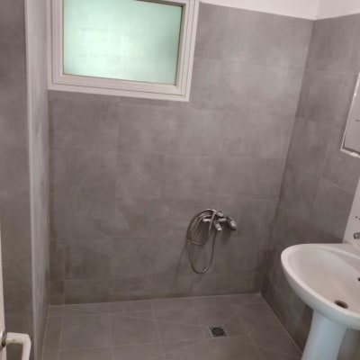 חדר אמבטיה עם אריחים אפורים וברז מותקן