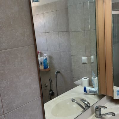 מראה בחדר אמבטיה עם כיור וברז