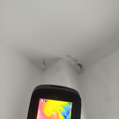 מד חום תרמי מציג נזילה בקיר לבן