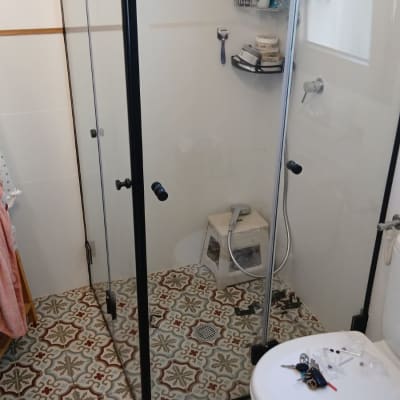 מקלחון עם מוצרי טיפוח וכלים על הרצפה