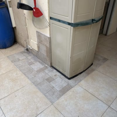 ארון פלסטיק וכלי גינון ליד קיר מרוצף