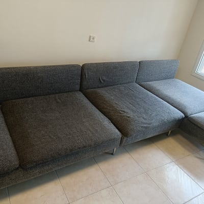 ספה אפורה על רצפת אריחים ליד חלון