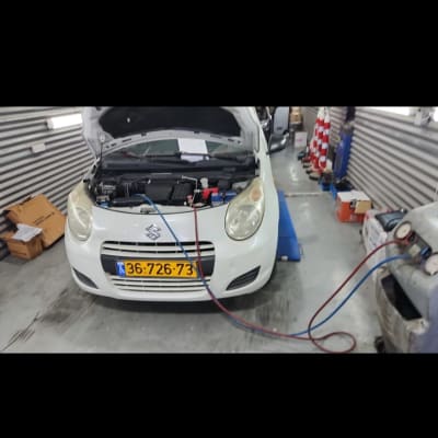 רכב עם מכסה מנוע פתוח במוסך חשמל רכב