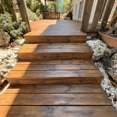 מדרגות עץ בגינה עם צמחייה מסביב