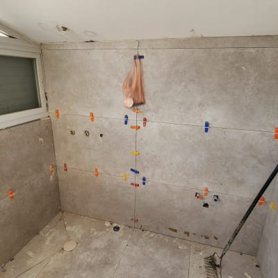 חדר אמבטיה בשיפוץ עם אריחים וכלי עבודה