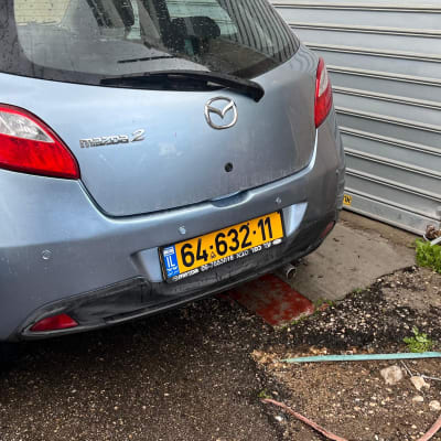 רכב חונה ליד דלת מתכת במוסך