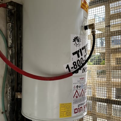 דוד שמש עם צינורות וחיבורים על קיר חיצוני