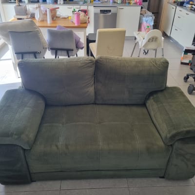 ספה ירוקה במטבח עם כיסאות ושולחן