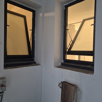 שני חלונות אלומיניום פתוחים בקיר לבן