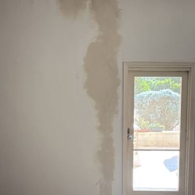 קיר עם סימני רטיבות ליד דלת זכוכית