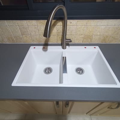 כיור כפול עם ברז על משטח שיש אפור