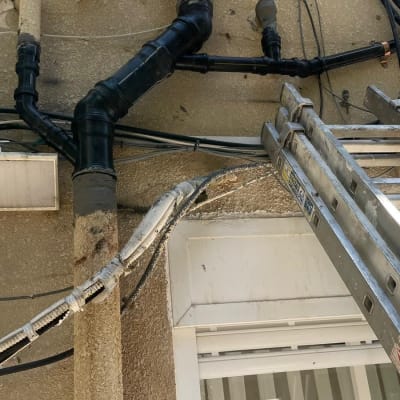 צינורות ביוב שחורים מחוברים לקיר חיצוני