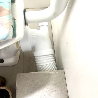 צינור ביוב לבן מחובר לאסלה בחדר אמבטיה