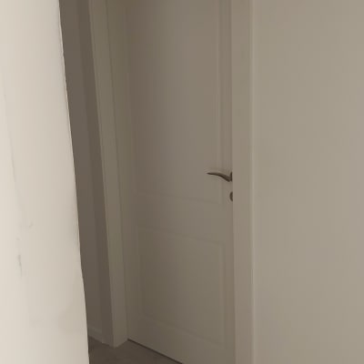 דלת לבנה עם ידית מתכת בחדר פנימי