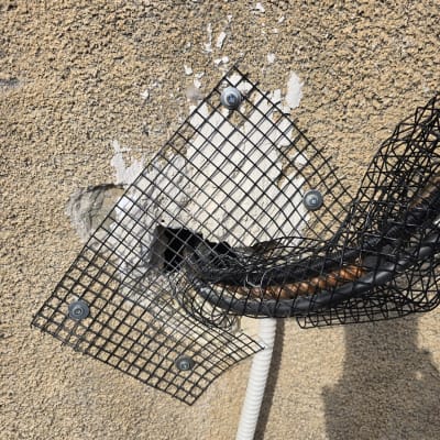 רשת מתכת מחוברת לקיר עם ברגים