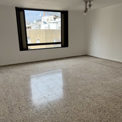 חדר ריק עם חלון גדול ורצפת שיש