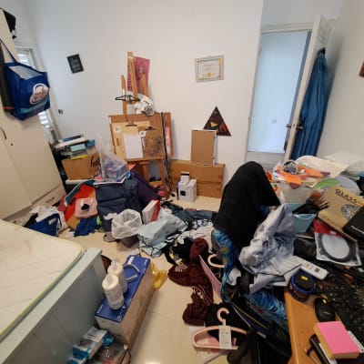 חדר מבולגן עם חפצים רבים על הרצפה והשולחן