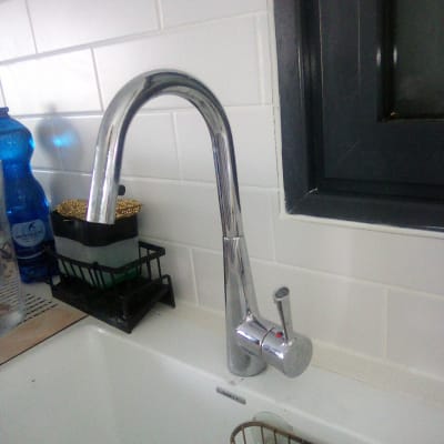 ברז כיור במטבח עם כלים לניקוי