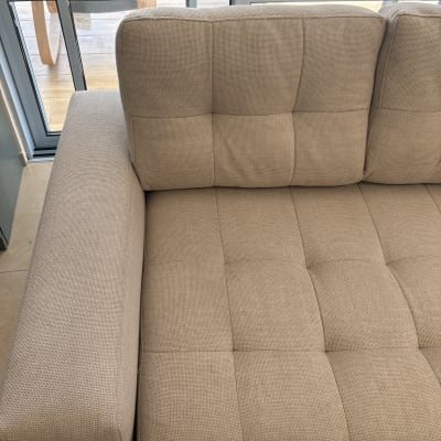 ספה נקייה ליד חלון עם אור שמש