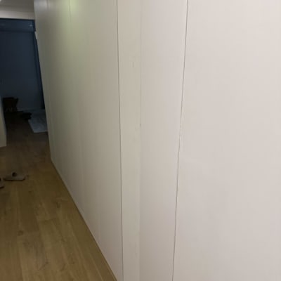 קיר עץ לבן במסדרון עם רצפת עץ