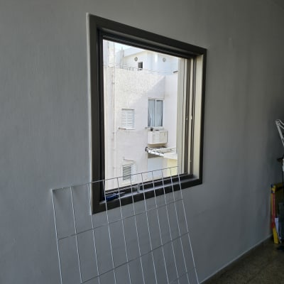 חלון עם מסגרת מתכת ליד קיר פנימי