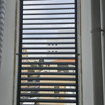 רשת מתכת על חלון למניעת כניסת יונים