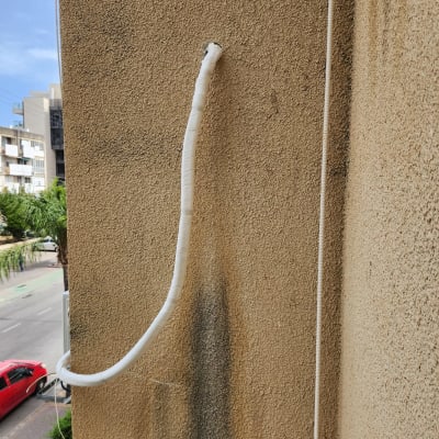 צינור מיזוג אוויר מחובר לקיר חיצוני