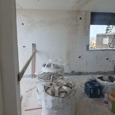 שקי פסולת בנייה בחדר במהלך שיפוץ