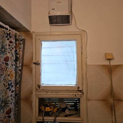 חלון עם תריסים וכלים לידו בחדר אמבטיה