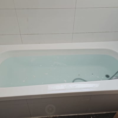 אמבטיה עם מים, ברז ומקלחת יד