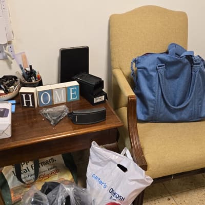 תיק כחול על כיסא, שקיות על הרצפה