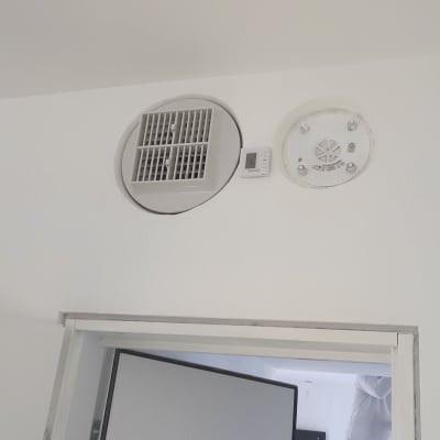 פתח אוורור עגול עם תריסים על קיר לבן