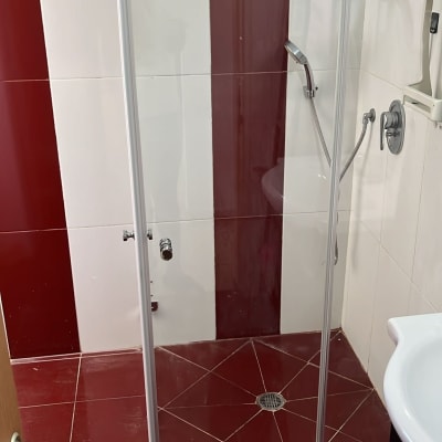 מקלחון עם דלת זכוכית וריצוף אדום לבן