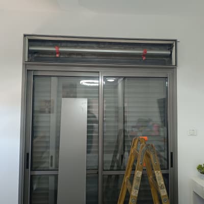 סולם מול חלון תריסים בתהליך התקנה