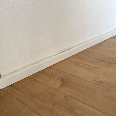 רצפת פרקט ליד קיר לבן עם פנלים